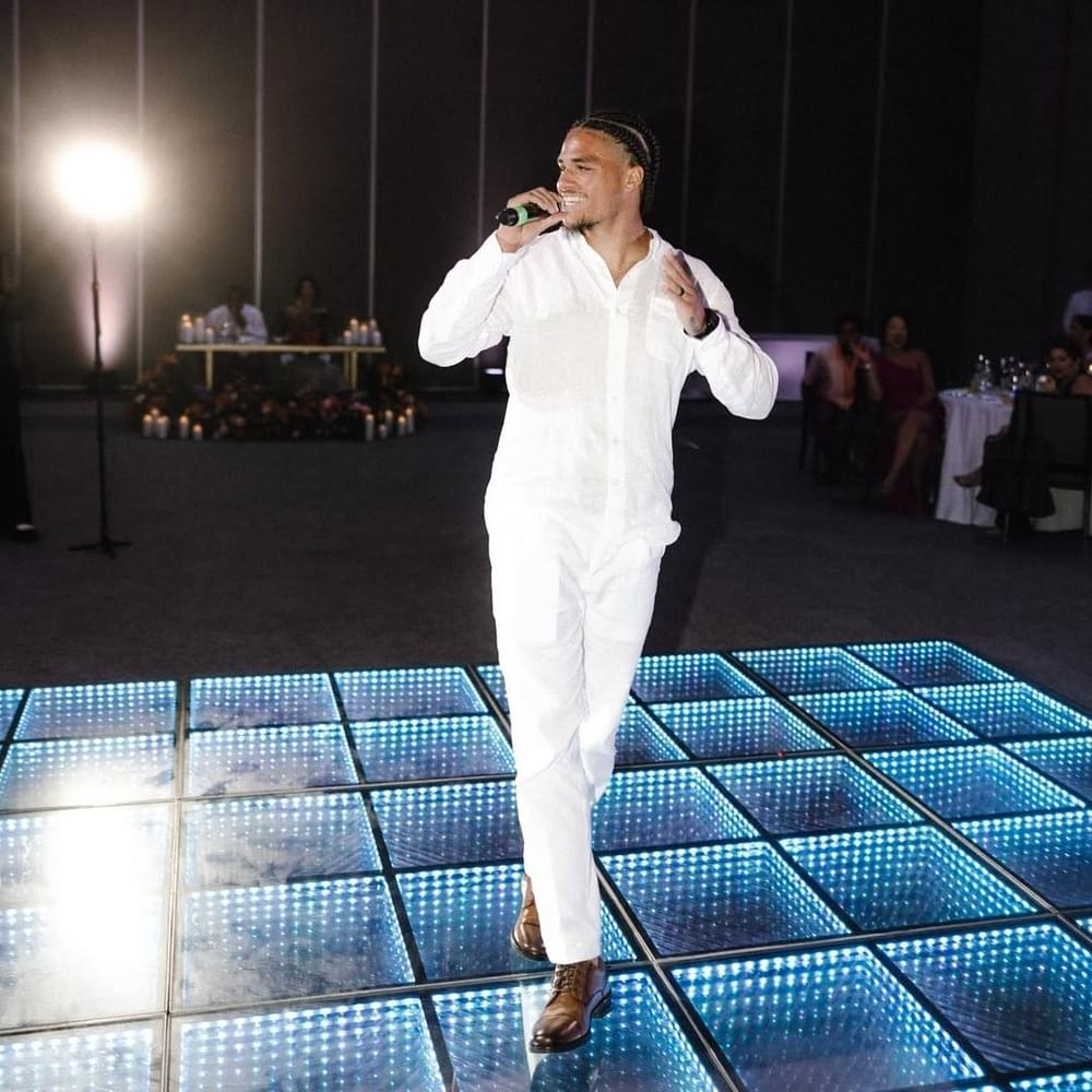 Deyton Jackson performing on a lit dance floor in all white